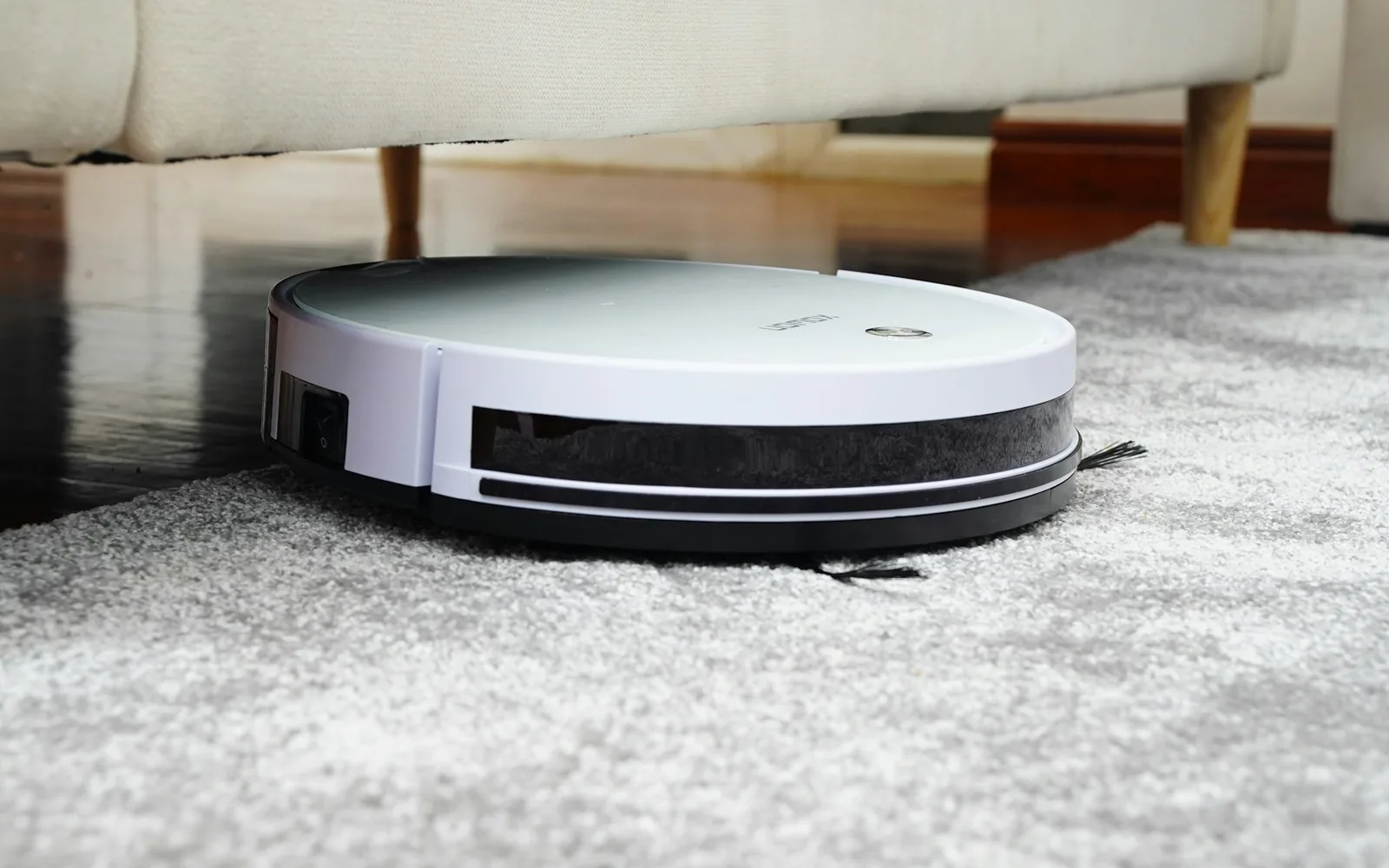 A compact vacuum cleaning a carpet in a modern home